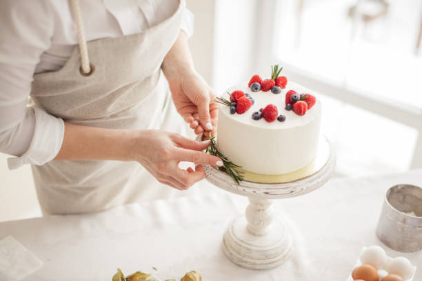 istock woman's hands putting greenery on the edge of cake 1227094892