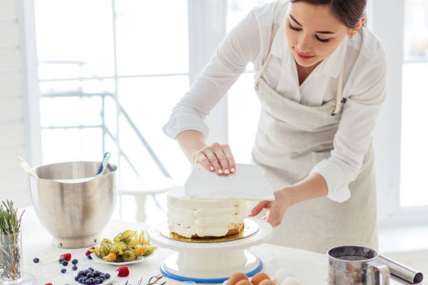 istock beautiful woman concentrated on smoothing cake 1227094971