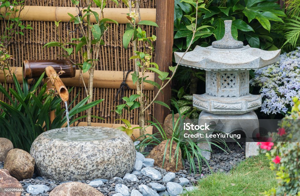 stone lantern and bamboo fountain. Oriental background stone lantern and bamboo fountain in Japanese garden Yard - Grounds Stock Photo