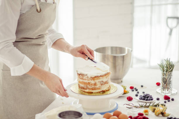 istock girl putting whipped cream on cake 1227096658