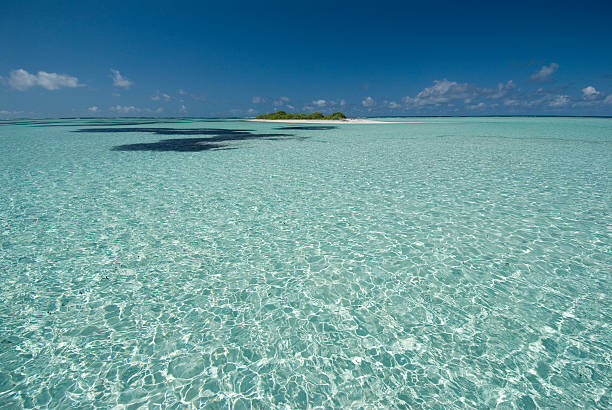 desert island surrounded by clear water stock photo