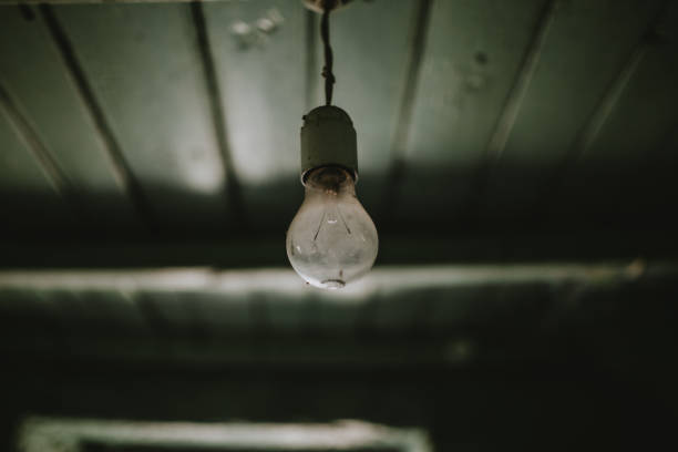 istock Close-Up Of Light Bulb Hanging From Ceiling 1227099392