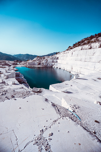Lake formation in an old abandoned quarry. Quarry lake. Crushed stone dumps in a closed area for stone extraction. Termination of mining operations.
