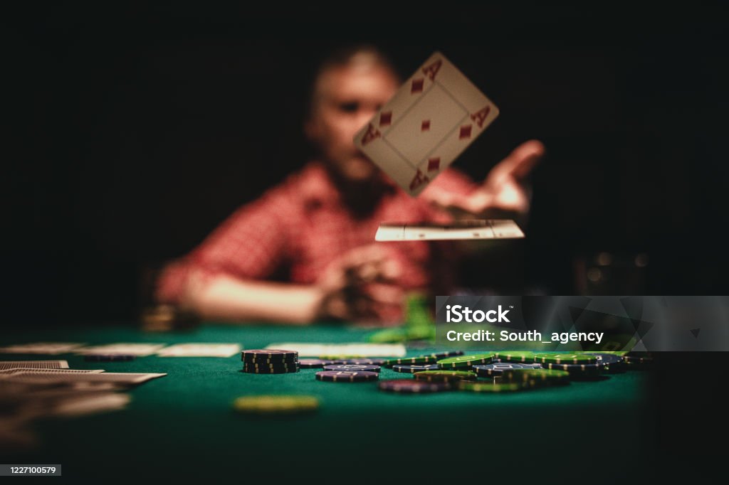 Mature man throwing playing cards on table One mature man playing poker late by night, throwing playing cards on table. Poker - Card Game Stock Photo