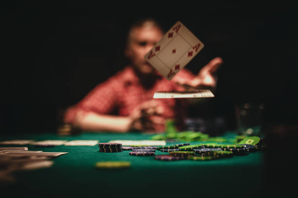 Mature man throwing playing cards on table One mature man playing poker late by night, throwing playing cards on table. texas hold em photos stock pictures, royalty-free photos & images