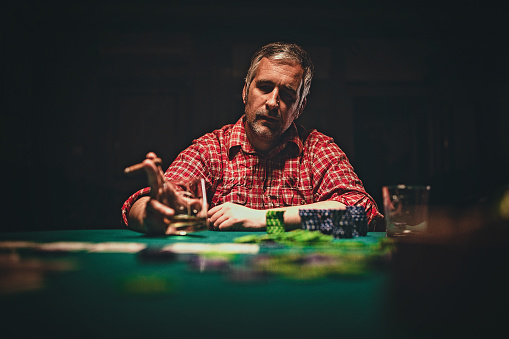 One mature man playing poker game late by night.