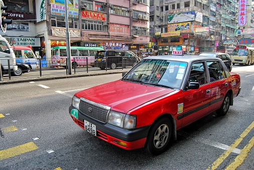 Urban Red Taxis in the street. The red taxis have the highest fares among all, and serve all areas of New Territories, Kowloon and Hong Kong Island.