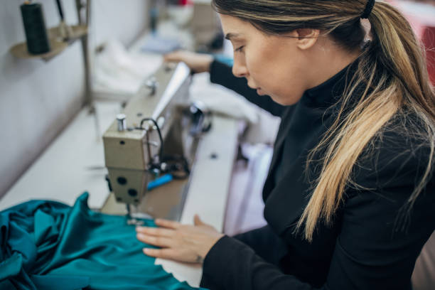 istock Female fashion designer working on sewing machine in her workshop 1227104144