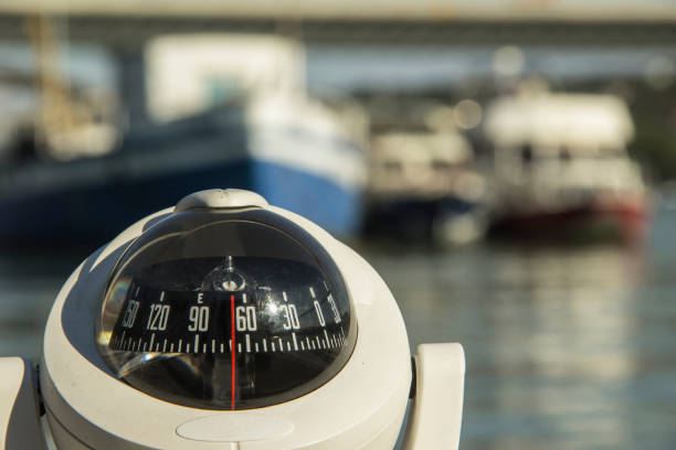 istock Close-up of a compass on a boat passing by the anchored ships 1227105421