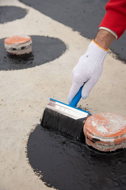 istock Worker applies bitumen mastic on the foundation 1227106848