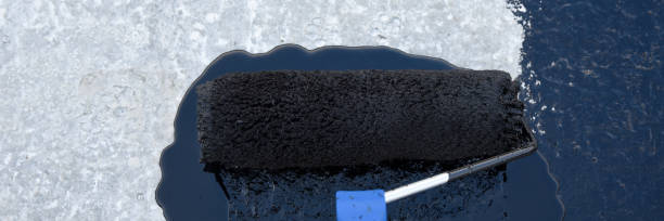 istock Worker applies bitumen mastic on the foundation 1227106862