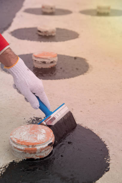 istock Worker applies bitumen mastic on the foundation 1227106864
