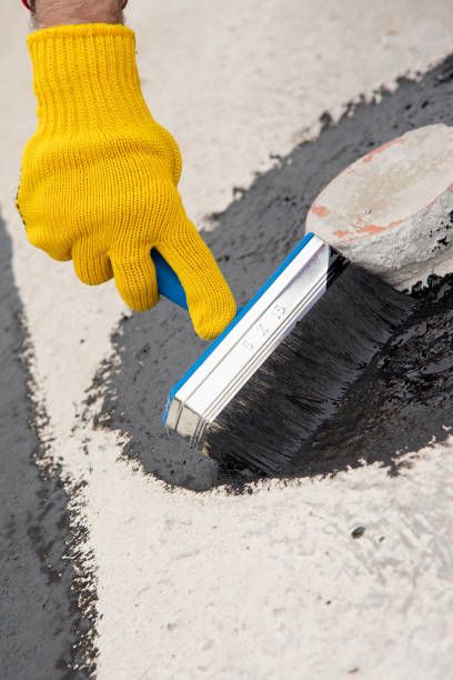 istock Worker applies bitumen mastic on the foundation 1227107055