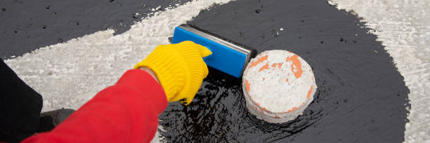 istock Worker applies bitumen mastic on the foundation 1227107074