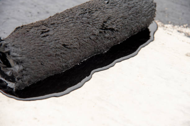 istock Worker applies bitumen mastic on the foundation 1227107097