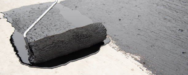 istock Worker applies bitumen mastic on the foundation 1227107176