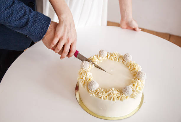 istock newlyweds cut the cake. hands closeup 1227109420