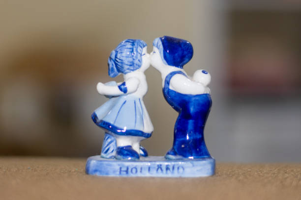 delft figurine blu di baciare coppia olandese. souvenir dall'olanda / paesi bassi. sfondo bokeh. - couple traditional culture pair close up foto e immagini stock