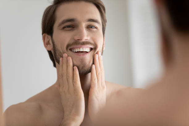 istock Smiling Caucasian man look in mirror touching face 1227112907