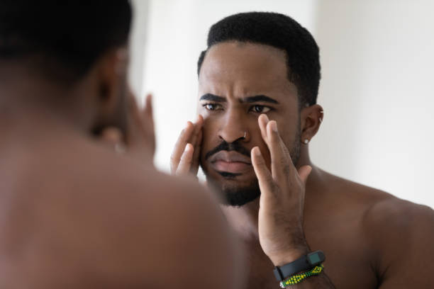 homem afro-americano ansioso preocupado com rugas faciais - mirror men depression african descent - fotografias e filmes do acervo