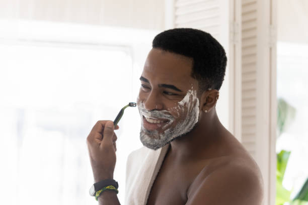 istock African american man look in mirror shaving in bath 1227113494