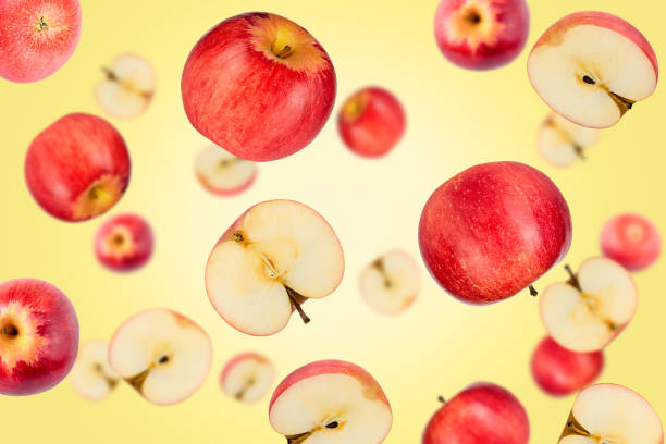 istock Falling red apples isolated on a yellow background with clipping path as package design element. Flying fruits 1227116570