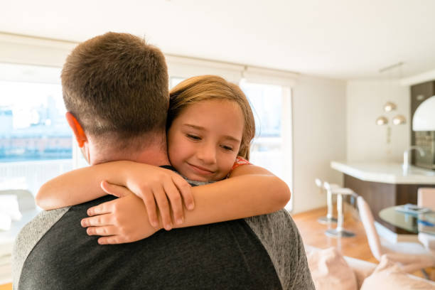 istock Little girl hugging her father at home 1227116661