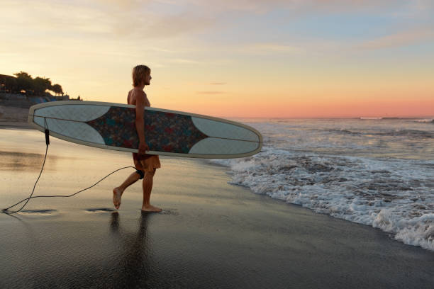 istock Surfer. Surfing Man With White Surfboard Walking On Sandy Beach. Water Sport For Active Lifestyle. Beautiful Ocean, Sea Sunset View. 1227121684