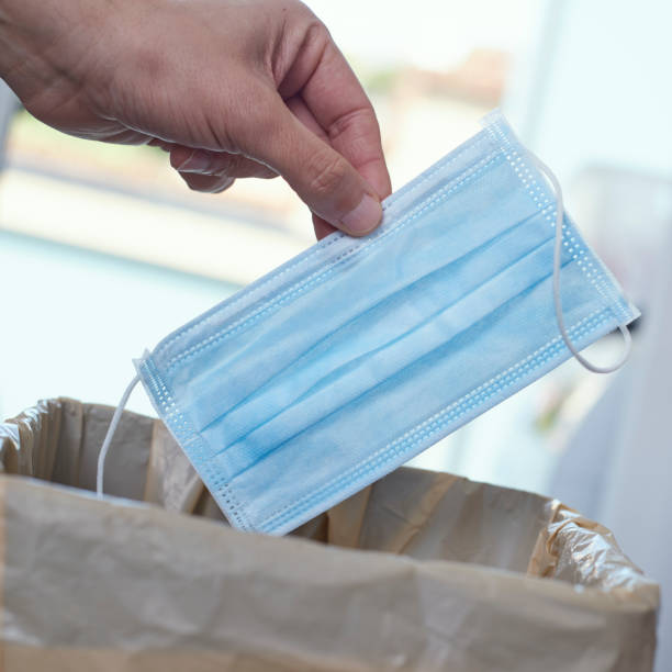 istock man throwing a surgical mask to the trash can 1227123753