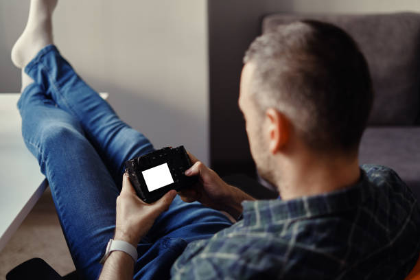 istock Photographer hold digital camera looking at white display 1227126042