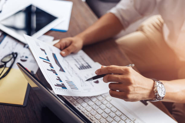 istock Businessman hold pen and working calculate data. document graph chart and report marketing. Business office concept. 1227127359