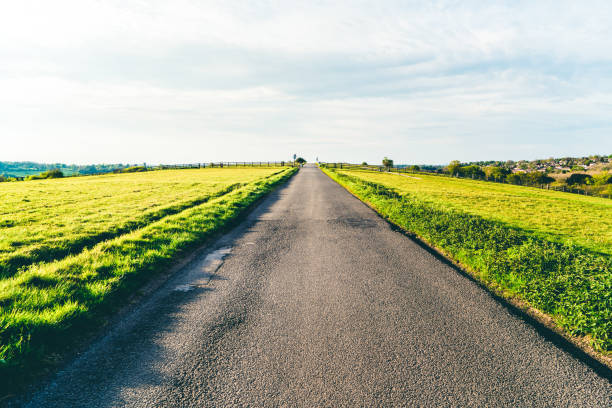 istock road in green field and mountains 1227131008