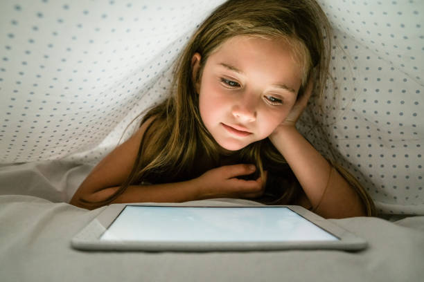 istock Cute girl using digital tablet in the bed 1227132200