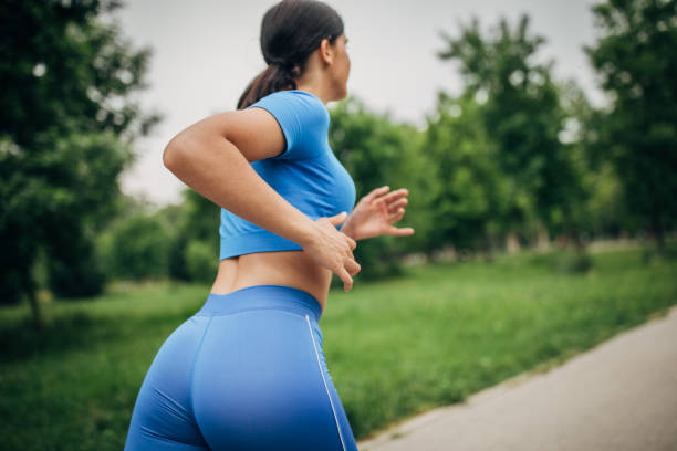istock Young woman jogging alone in park 1227132215