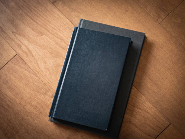 istock Two black notebooks on the brown maple wooden table 1227132528