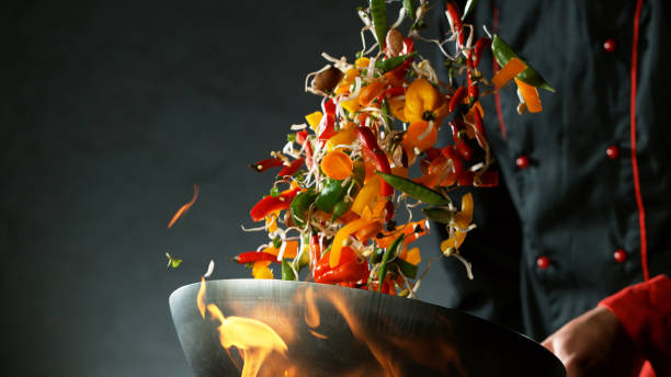 istock Closeup of chef throwing vegetable mix from wok 1227134118