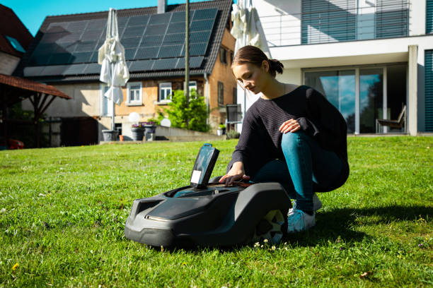 istock Woman in Home Garden programming Robotic Lawn Mower 1227135266
