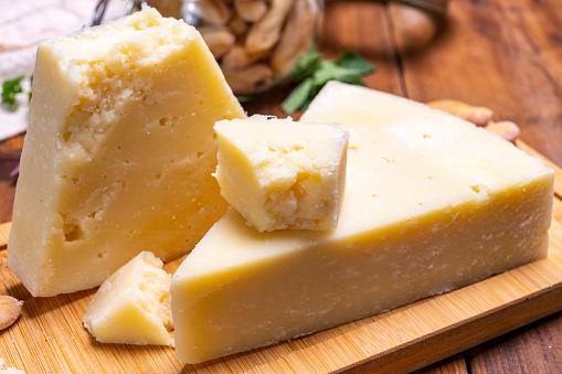Pieces of matured pecorino romano italian cheese made from sheep milk in Lazio, Sardinia or Tuscany close up