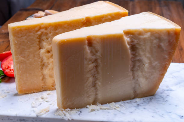 grandes cuñas de parmigiano-reggiano parmesano duro queso italiano hecho de leche de vaca o grana padano - gran padano fotografías e imágenes de stock
