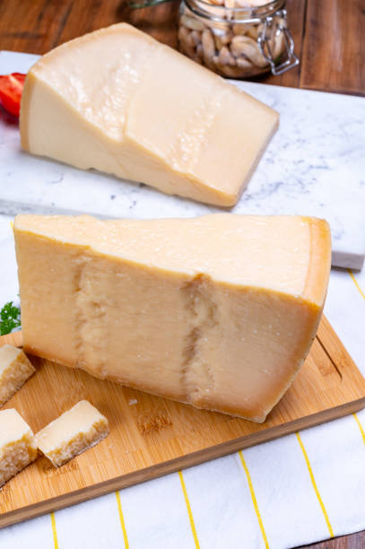 grandes cuñas de parmigiano-reggiano parmesano duro queso italiano hecho de leche de vaca o grana padano - gran padano fotografías e imágenes de stock