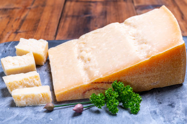 gran cuña de parmigiano-reggiano parmesano duro queso italiano hecho de leche de vaca o grana padano - gran padano fotografías e imágenes de stock