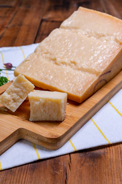 gran cuña de parmigiano-reggiano parmesano duro queso italiano hecho de leche de vaca o grana padano - gran padano fotografías e imágenes de stock