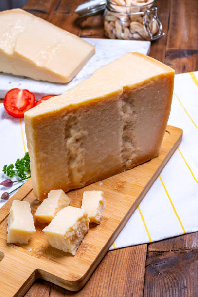 grandes cuñas de parmigiano-reggiano parmesano duro queso italiano hecho de leche de vaca o grana padano - gran padano fotografías e imágenes de stock