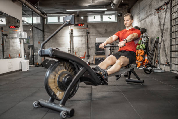 istock Man doing cardio workout on rowing machine in gym 1227135902