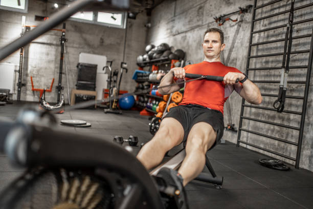 istock Man doing cardio workout on rowing machine in gym 1227135967