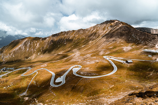 Alpine winding road in Austria surrounded by mountains.