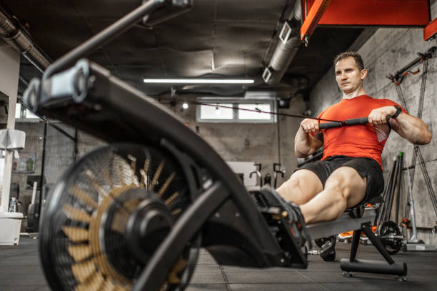 istock Man doing cardio workout on rowing machine in gym 1227136940
