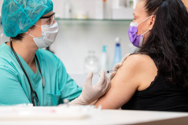istock Nurse in protective workwear injecting vaccine into senior woman's arm 1227138055