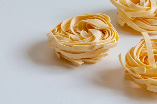 istock Italian unprepared taglitelli pasta on a white background. 1227138365