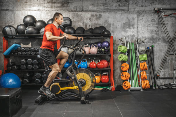 istock Man exercising on bike at gym 1227138496